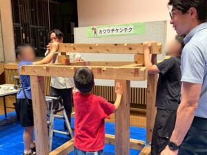 小さな家づくり体験で子どもたちが協力して組み立てている様子