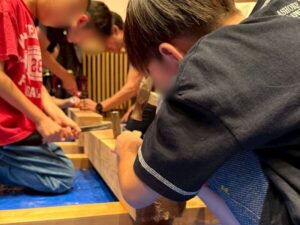 小さな家づくり体験で男の子が金づちを使っている様子