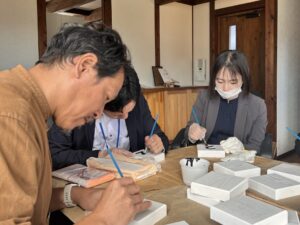 一文字一文字を丁寧に塗り進めるスタッフたち。その顔は真剣そのものです。