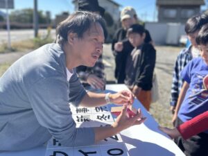 木片をどんな風に貼っていくかをレクチャーする、カワウチケンチク代表