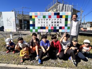 完成した看板の前で子どもたちと笑顔で撮影。